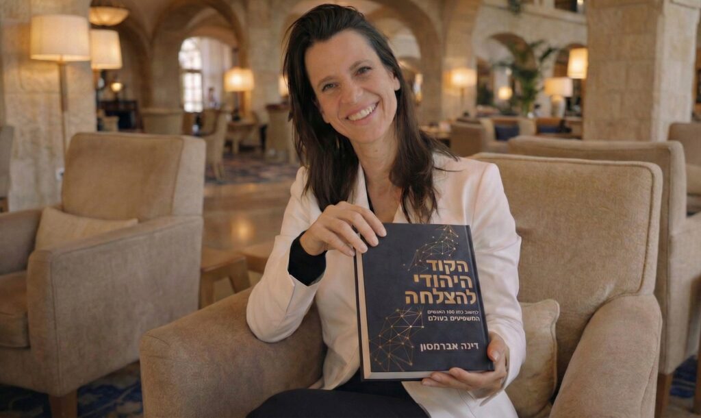 דינה אברמסון מחזיקה את ספר הקוד היהודי להצלחה